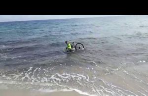 Ciclista entra in mare con la bici per cercare di evitare il controllo | Video